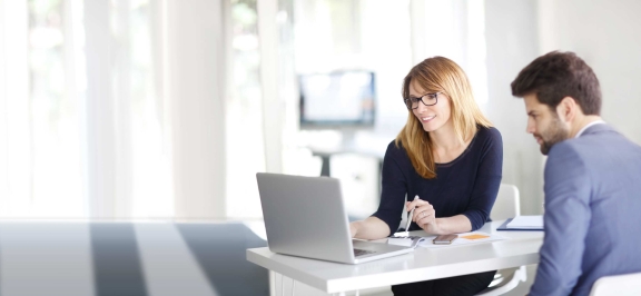 Mann und Frau sitzen bei Laptop